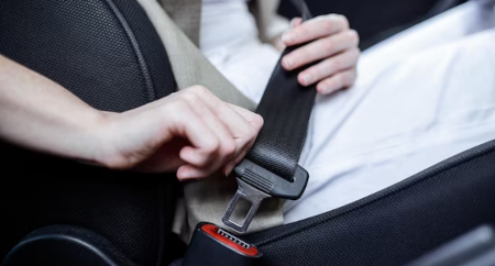 Image of a driver buckling their seatbelts