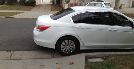 image of parked car partially blocking a driveway