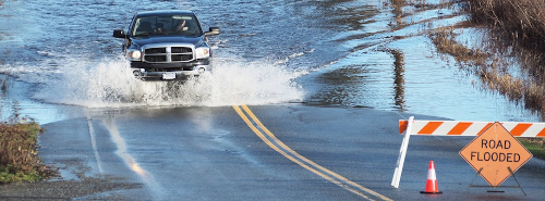 Image of a pickup truck driving on a flooded road