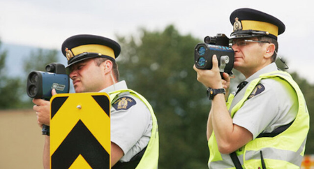 two rcmp officers using laser to measure vehicle speeds