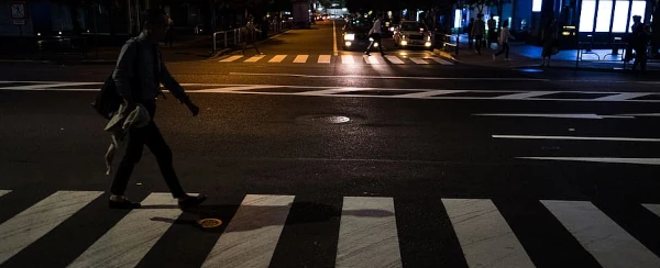 image of a pedestrian in a crosswalk at night