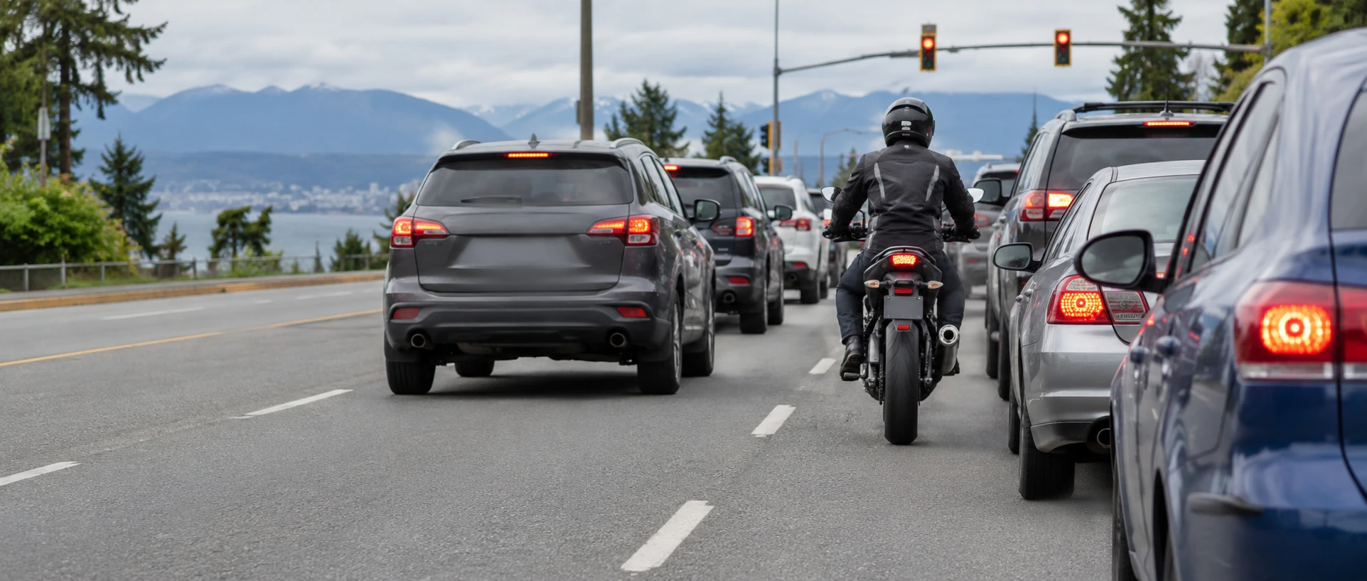 Motorcyclist travelling between lanes of stopped traffic on an urban road